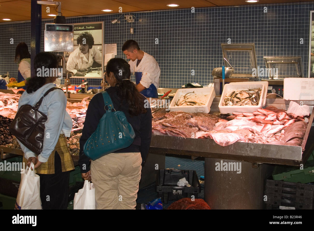 I clienti acquistano il pesce dal mercato britannico a Cork in Irlanda. Foto Stock