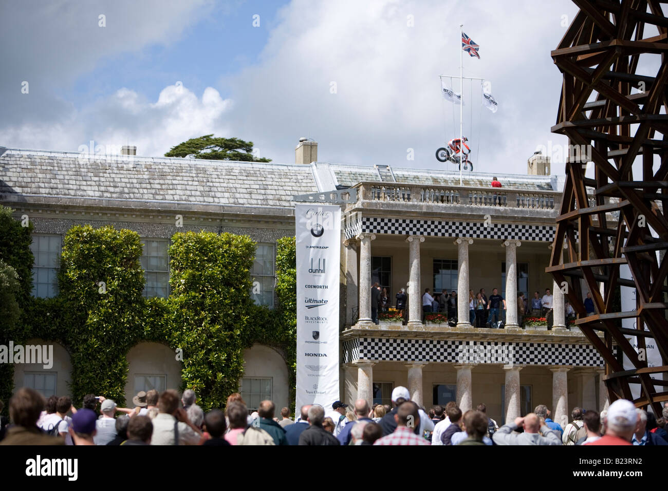 Stunt rider, Dougie Lampkin, sul tetto della casa di Goodwood con la folla a guardare Foto Stock