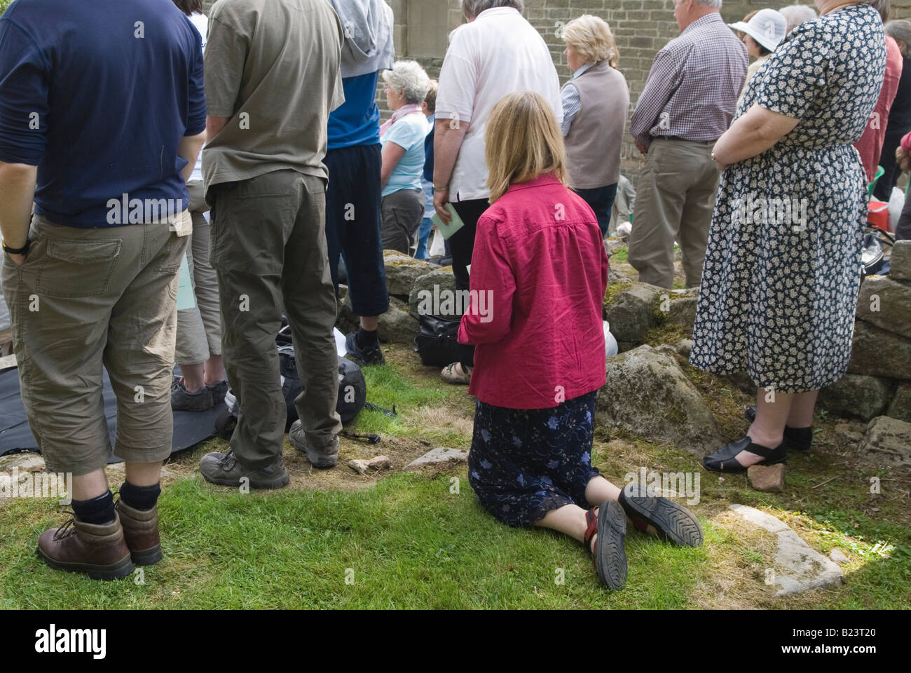 Donna in ginocchio per pregare il servizio chiesa all'aperto Padley Martyrs Annual Roman Catholic Pilgrimage, Padley Chapel Grindleford. Derbyshire Inghilterra Regno Unito Foto Stock