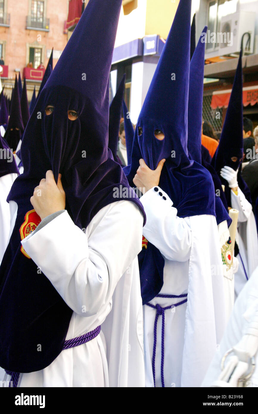 I penitenti in punta, violet cappe e vesti bianche, semana santa, Siviglia, Spagna Foto Stock