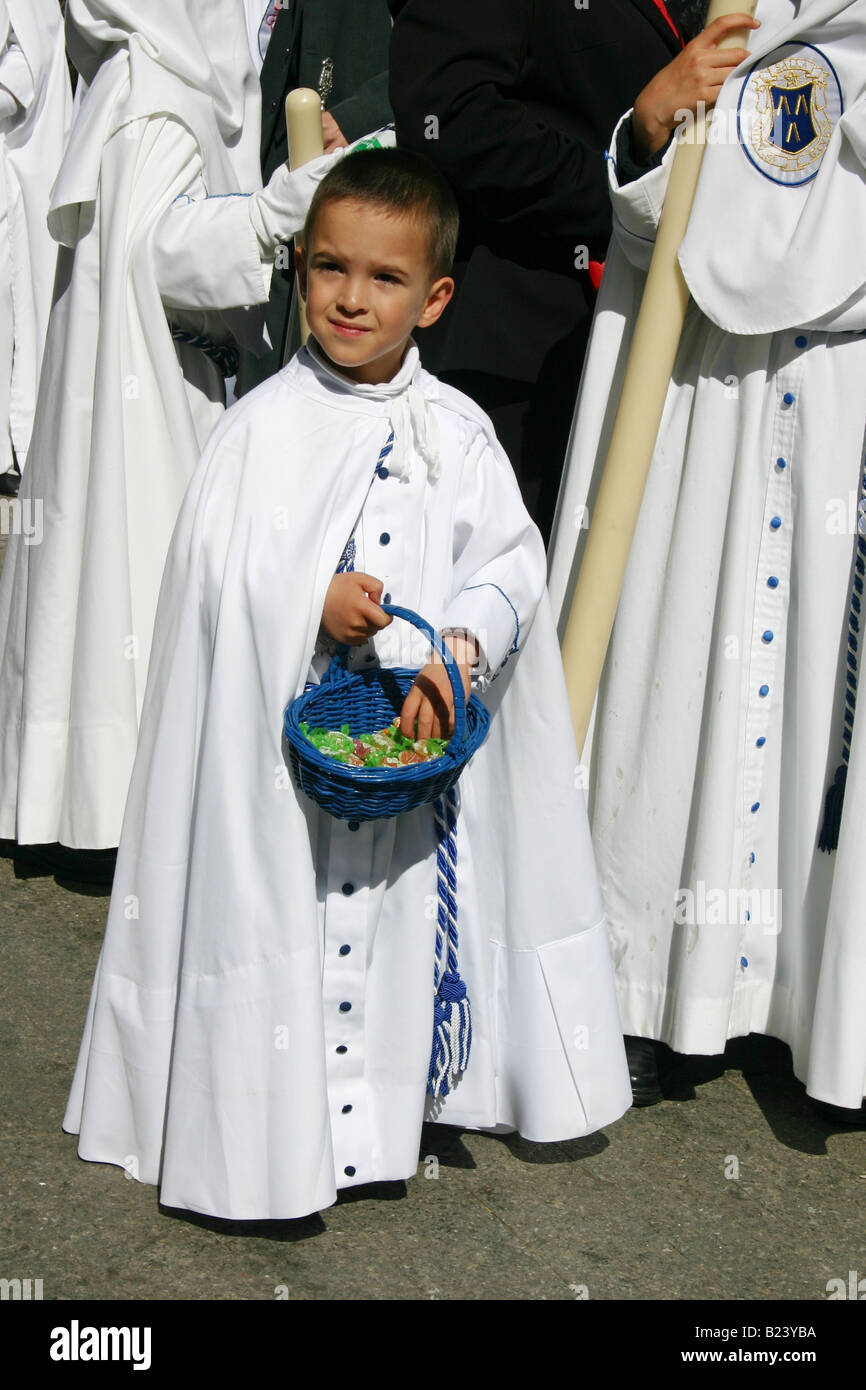 Pentinent ragazzo con un cesto di caramelle durante la Semana Santa processione, Siviglia, Spagna Foto Stock