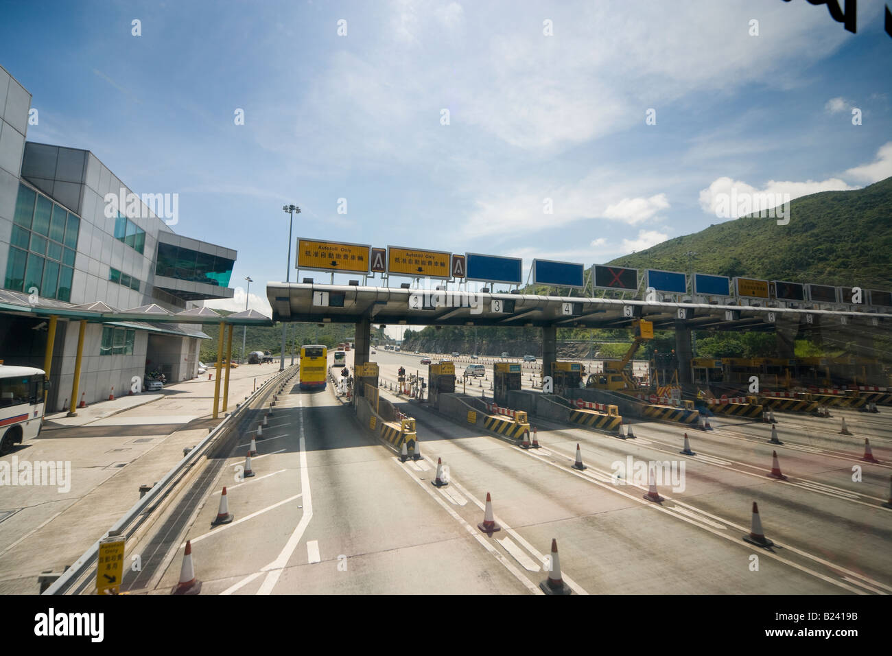 Hong Kong Tsing Ma Bridge toll gates visibile attraverso il parabrezza dal livello superiore di un doppio bus arredato. In una tranquilla Domenica. Foto Stock