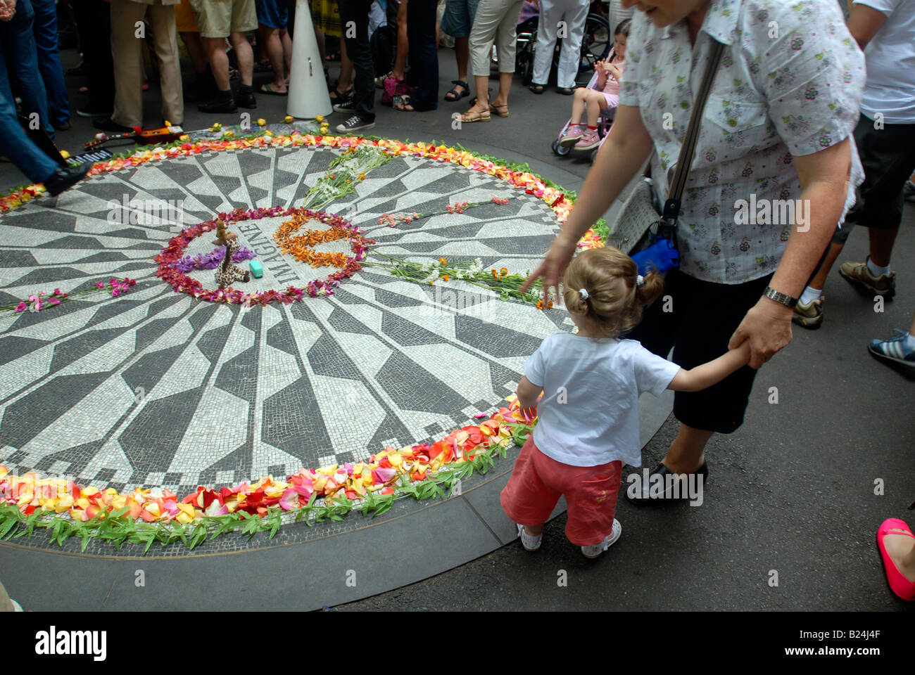 I visitatori a immaginare il mosaico in Strawberry Fields memorializing John Lennon in Central Park di New York Foto Stock