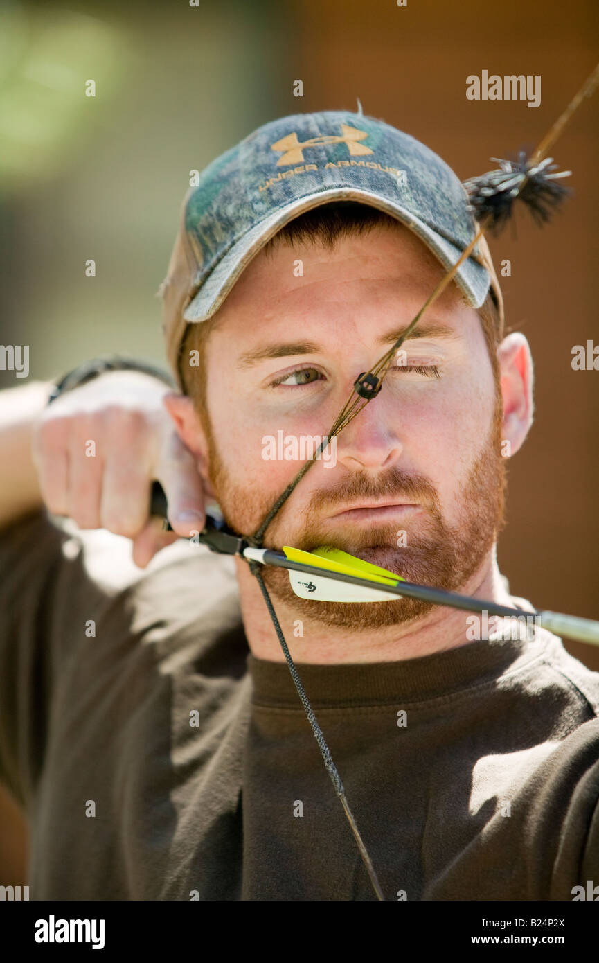 Un cacciatore si tira indietro sul suo arco freccia Foto Stock