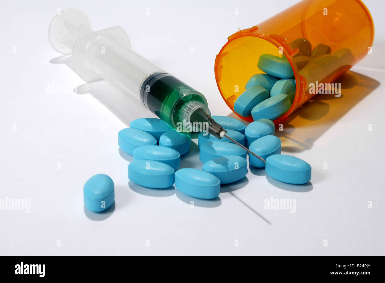 Pillole e la siringa su una luce sfondo neutro Foto Stock