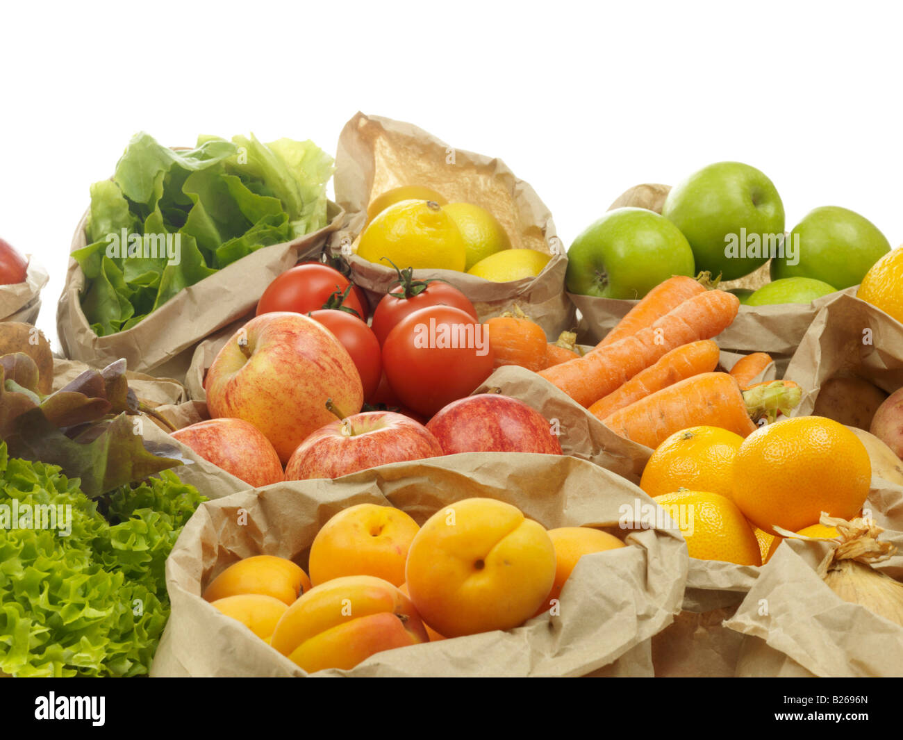 E una selezione di fresche sano e naturale di frutta e verdura in borse di carta marroni con n. di persone Foto Stock