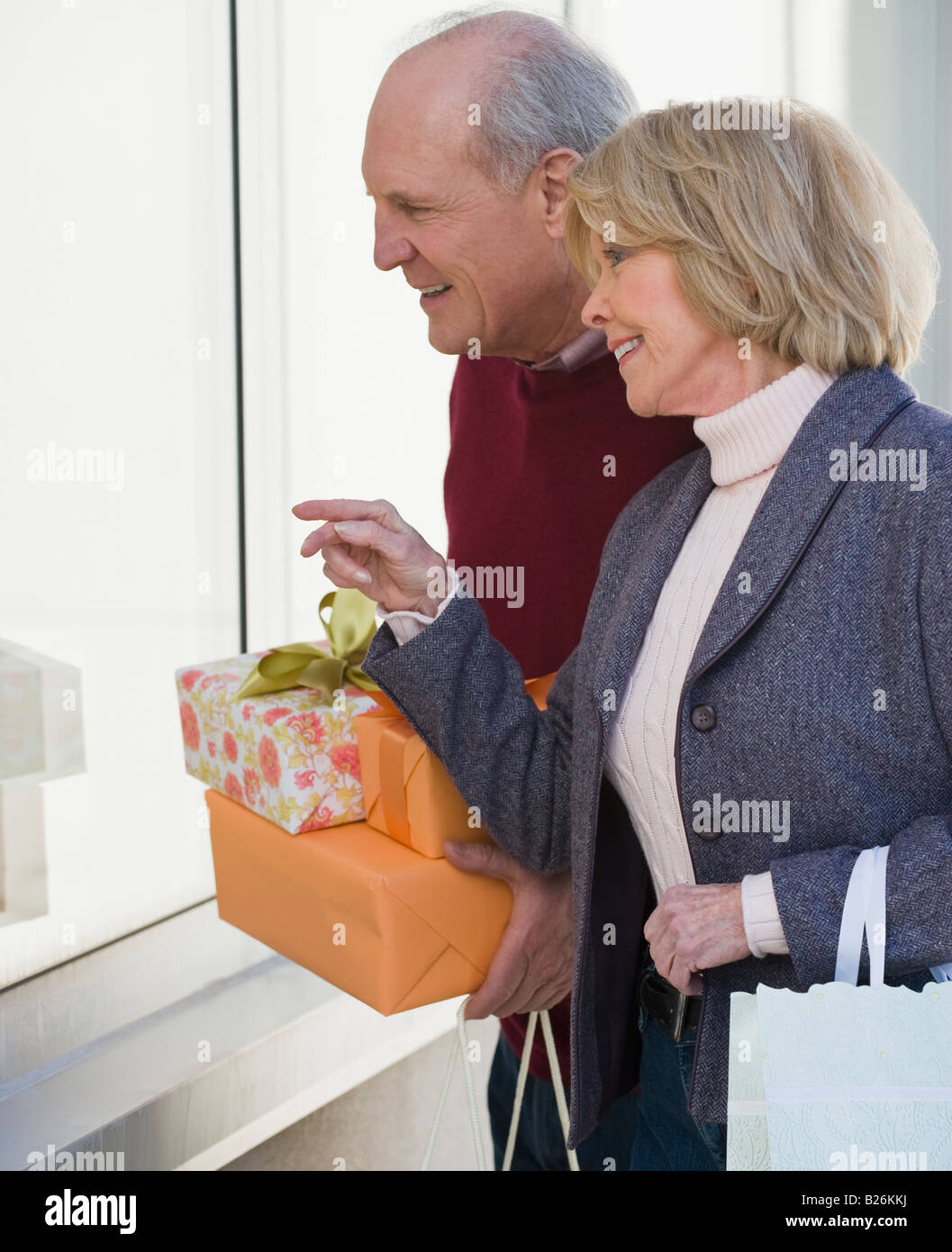 Coppia senior azienda doni accanto alla finestra Foto Stock