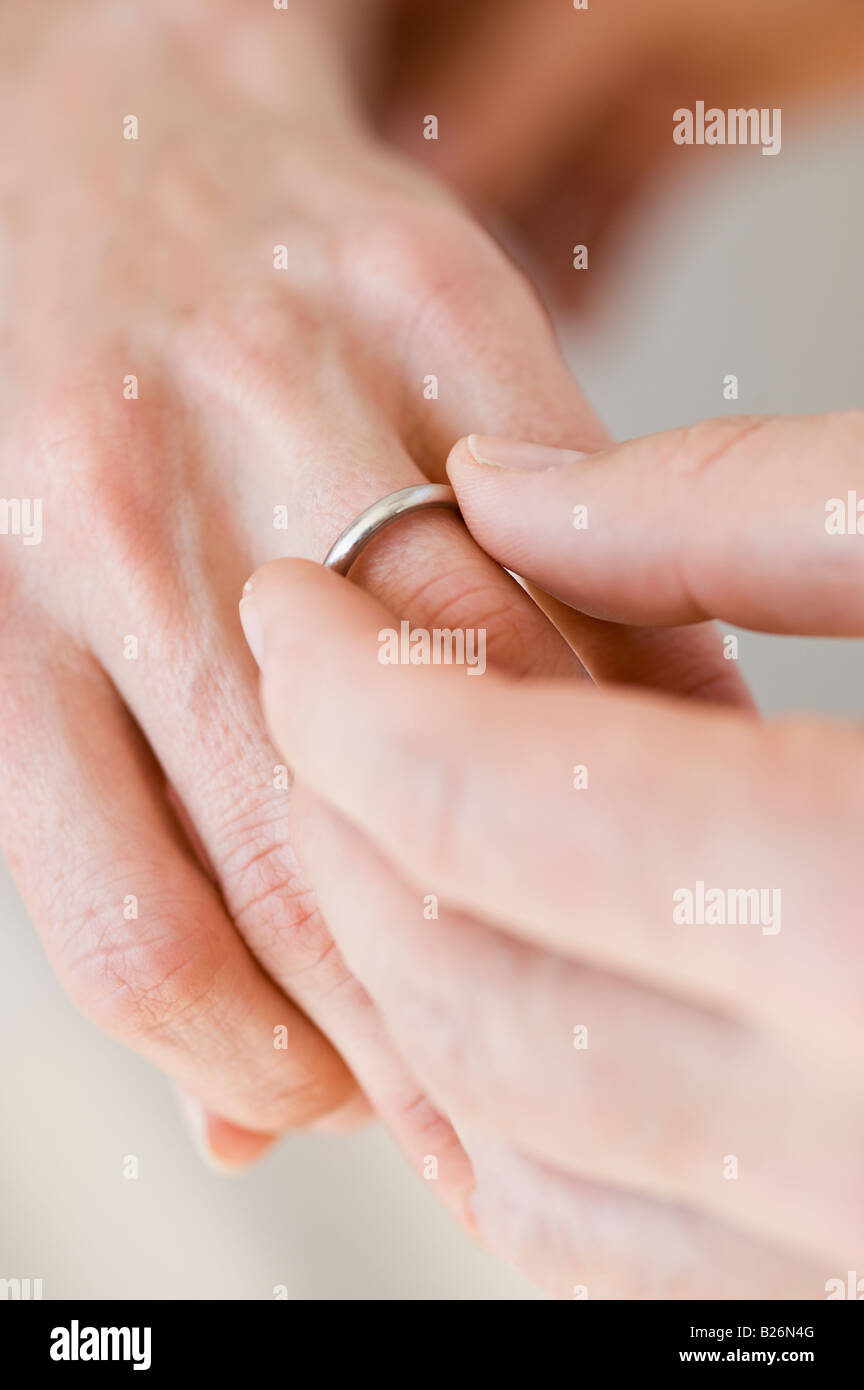 Uomo di mettere l'anello nuziale sulla donna del dito Foto Stock