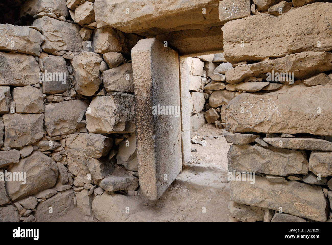 Pietra pesante porta in castello nel deserto Qusar Al Azraq Giordania Arabia Foto Stock