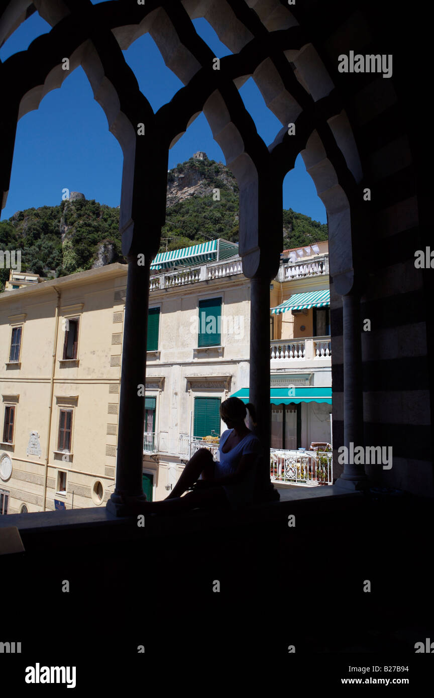 Una giovane ragazza seduta nel sottotetto della chiesa in una piccola città in Italia e si affaccia la chiesa passi riportati di seguito Foto Stock