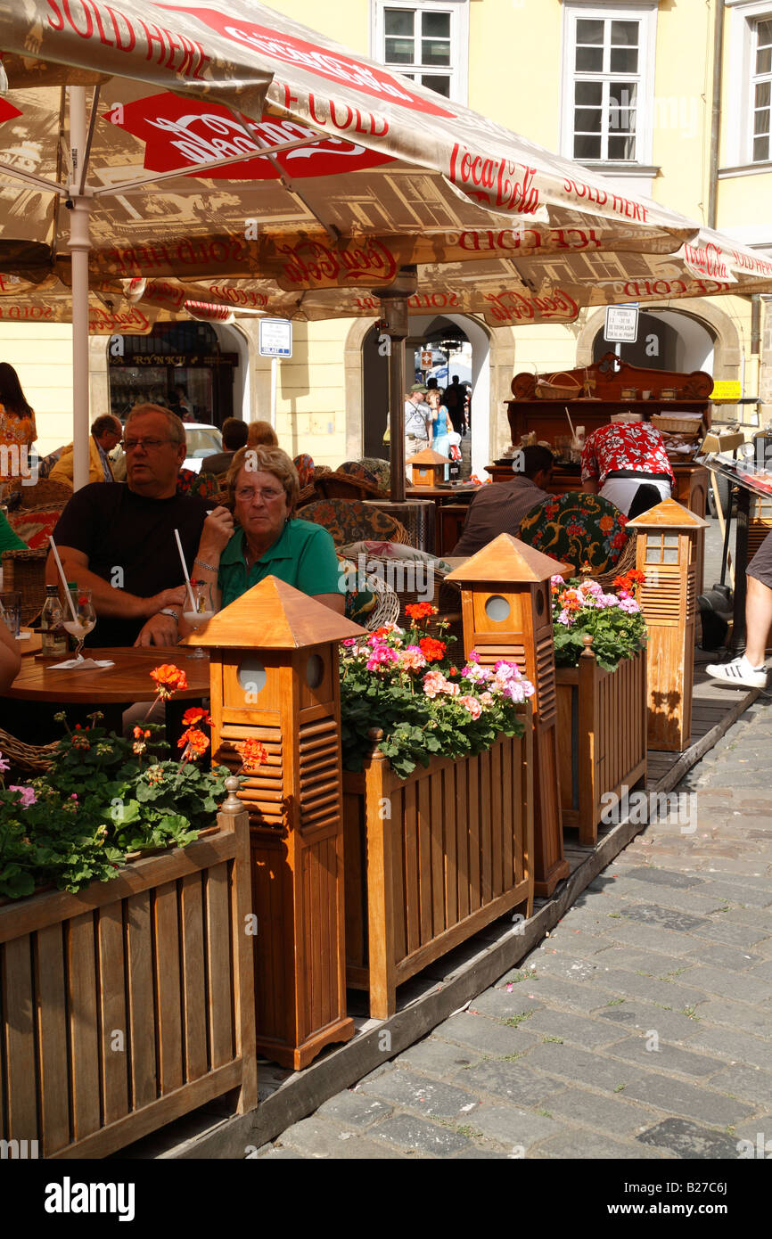 Turisti e visitatori di gustare drink e pasti impostazioni colorati presso il cafe aperto decorato con fiori Foto Stock