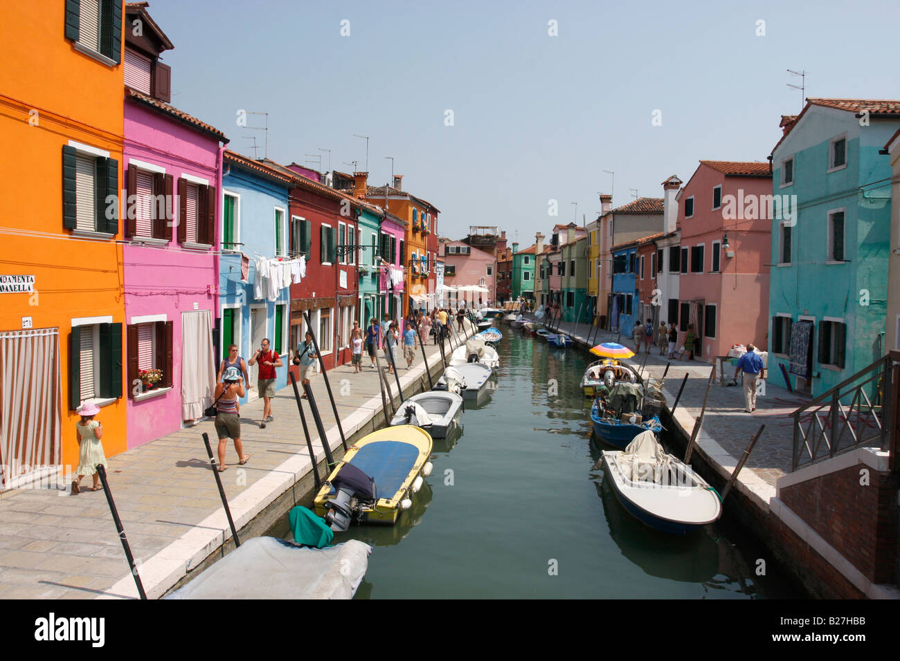 Fila di dipinto luminosamente case e barche lungo un canale di Burano,Laguna veneziana,Italia Foto Stock