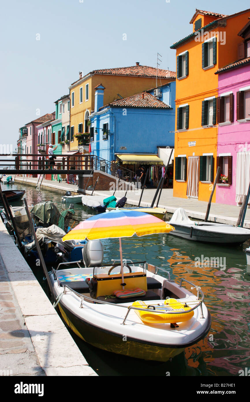 Fila di dipinto luminosamente case e barche lungo un canale di Burano,Laguna veneziana,Italia Foto Stock