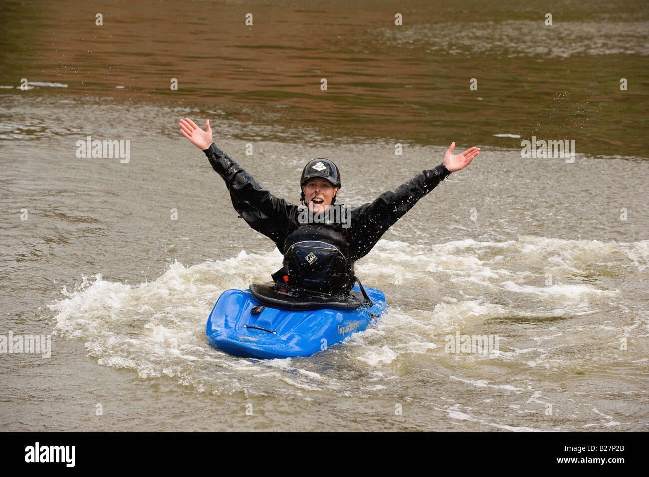 Sorridente kayaker caucasica, armi in aria seduto in un playboat blu nel bacino di Foss. York. REGNO UNITO. York River Festival 2008. Foto Stock