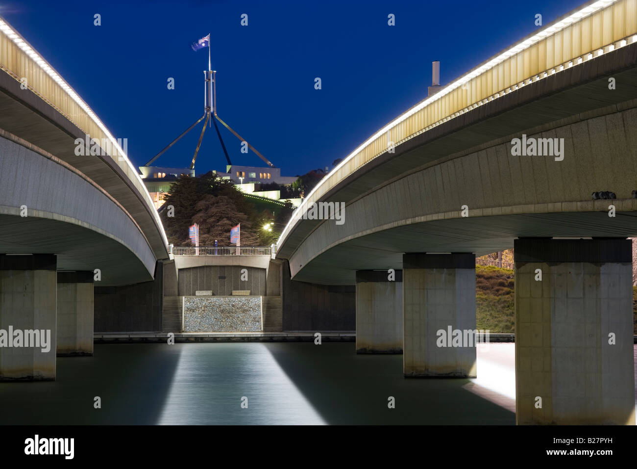 Canberra Australian Parliament House con asta di bandiera vista attraverso il ponte di Commonwealth Avenue sul lago Burley Griffin, Canberra Australia Foto Stock