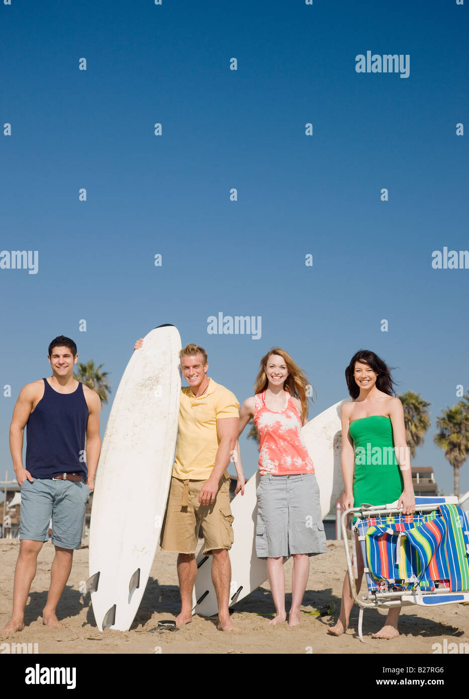 Gruppo di amici in piedi sulla spiaggia Foto Stock