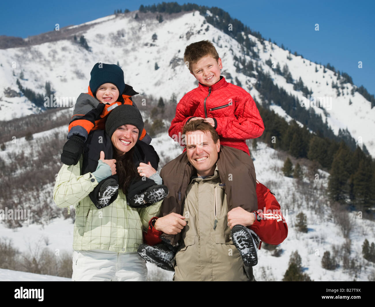 Famiglia nella parte anteriore della montagna innevata Foto Stock