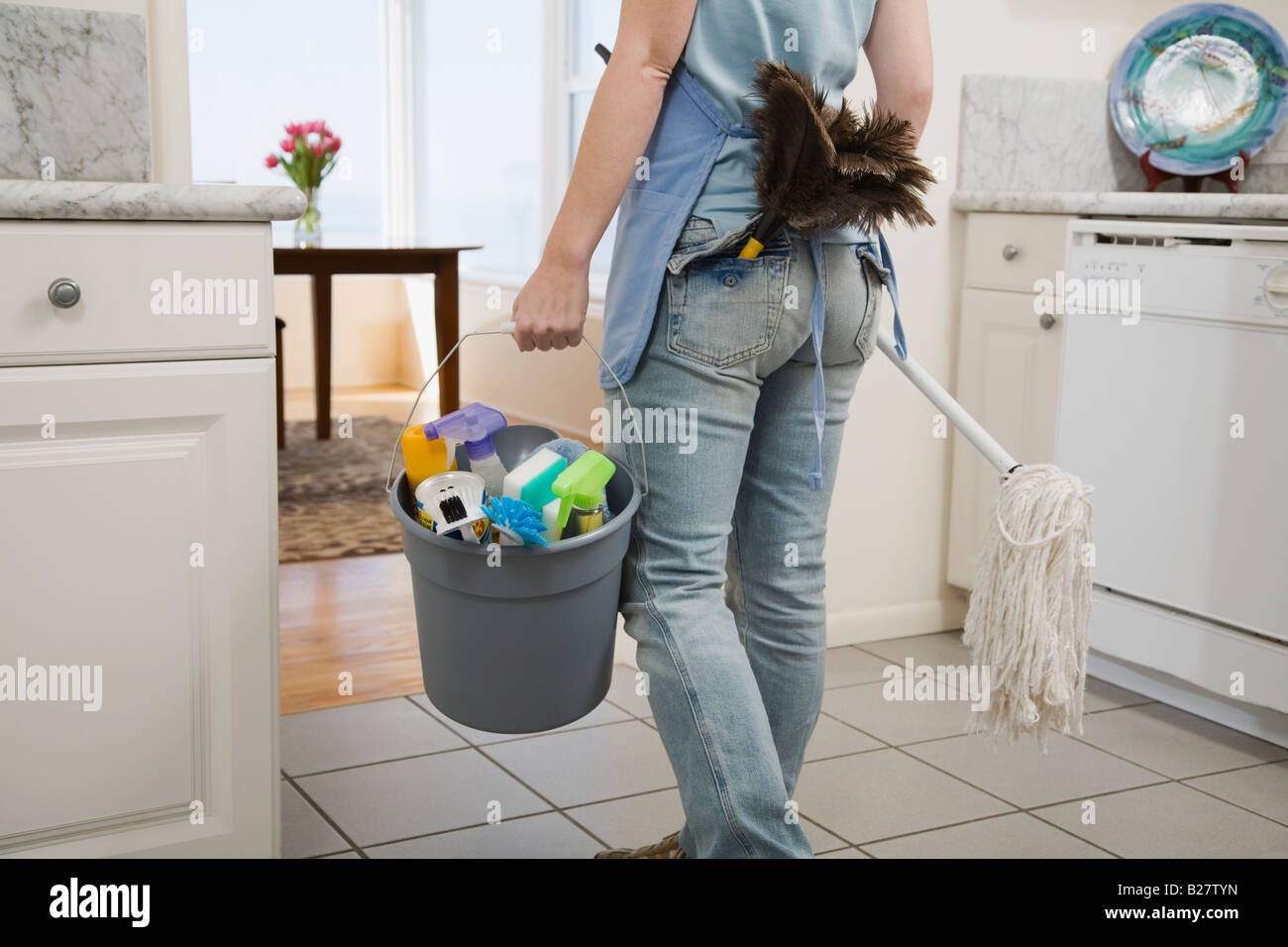 Donna che mantiene mop e materiali per la pulizia Foto Stock