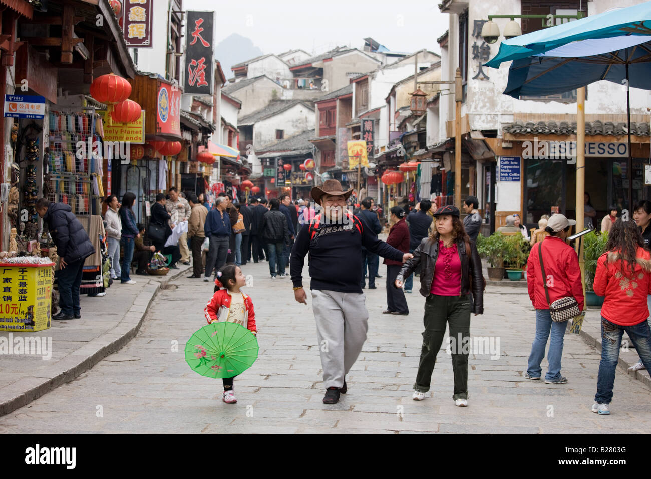 Famiglia turistico nella strada dello shopping Yangshuo la Cina ha una politica di bambino per limitare la popolazione Foto Stock