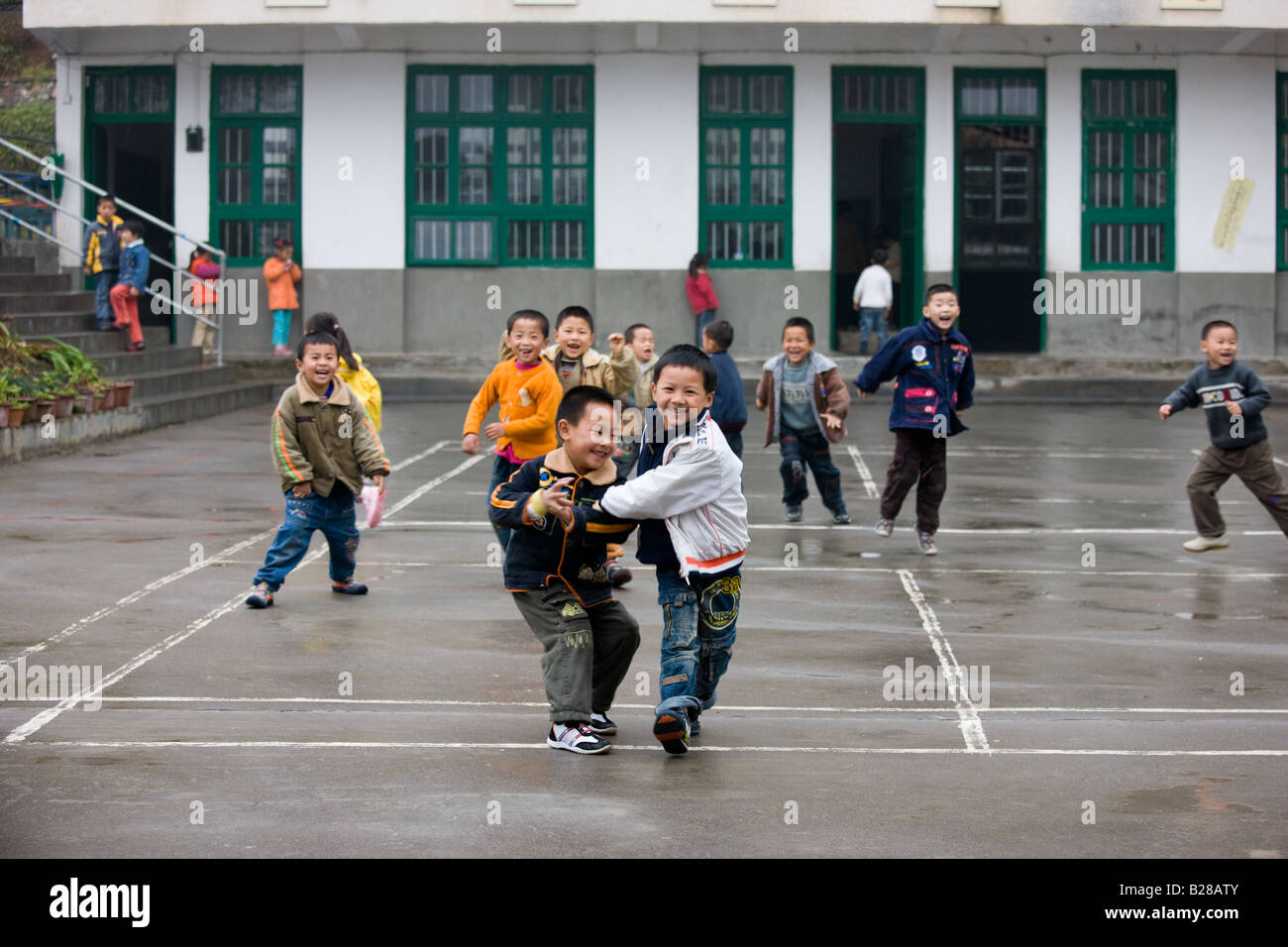 I bambini che giocano nel parco giochi di una scuola primaria in Fuli la Cina ha una politica di bambino per limitare la popolazione Foto Stock