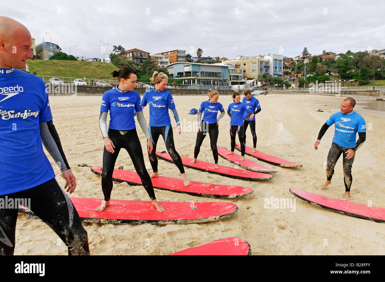 Surfers l'ascolto delle istruzioni durante lezioni di surf a Bondi Beach, Sydney, Nuovo Galles del Sud, Australia Foto Stock