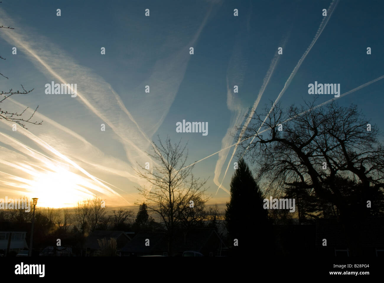 Più contrail da aerei in cielo che mostrano la traiettoria di volo su Midhurst, Sussex, Regno Unito, Sunrise Foto Stock