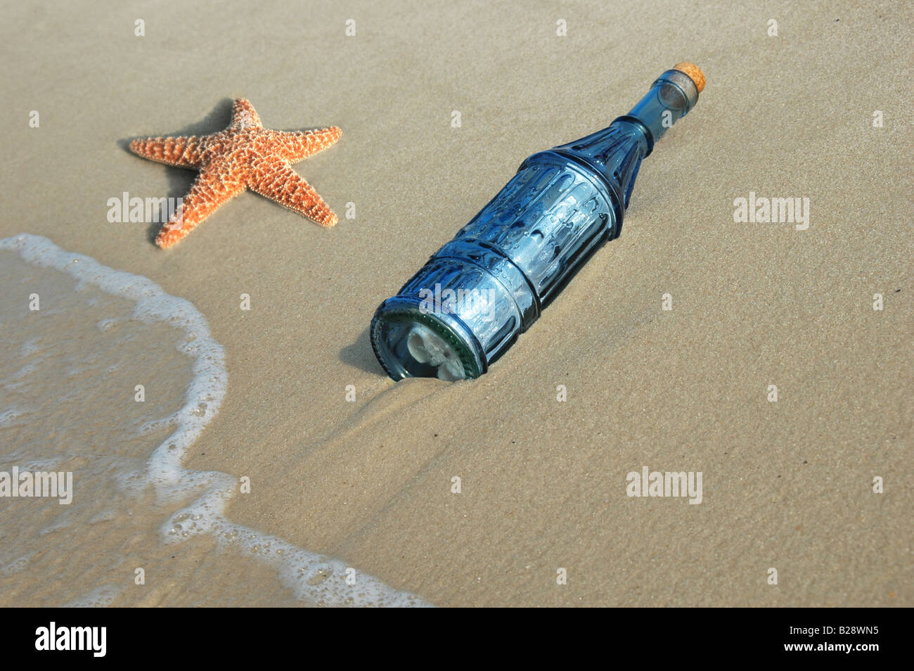 Starfish e messaggio in una bottiglia vintage sulla riva Foto Stock