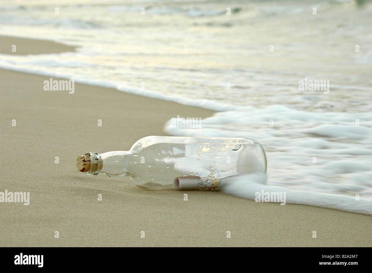 Un messaggio in bottiglia di essere colpiti dalle onde su una riva lontana Foto Stock