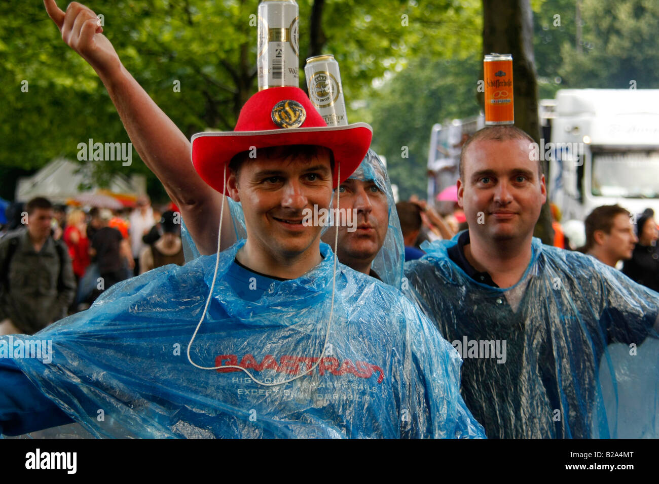 Techno fans in posa con lattine di birra sotto la pioggia a Love Parade 2008 a Dortmund Germania Foto Stock