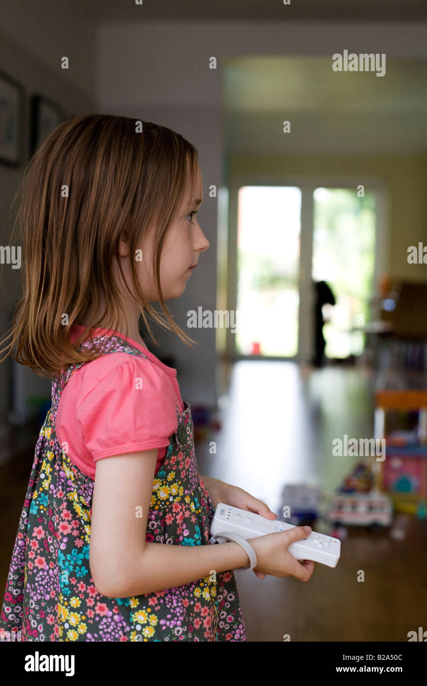 Giovane ragazza tenendo un Nintendo Wii controller Foto Stock