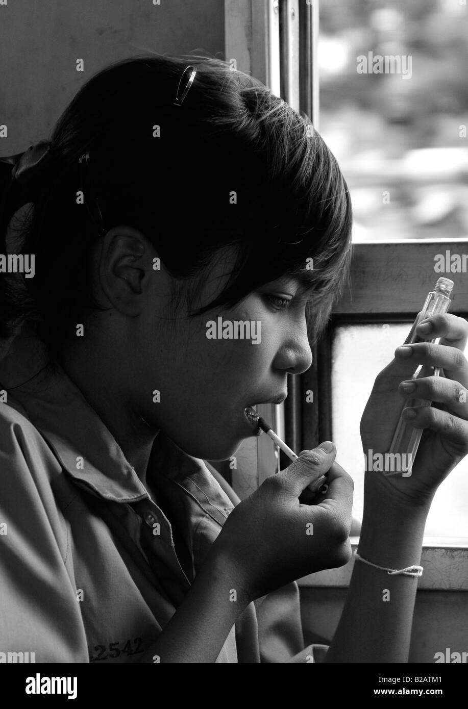 Ragazza giovane di applicare il make up, un treno lento per samutsakorn,viaggio in treno da bangkok, Thailandia Foto Stock