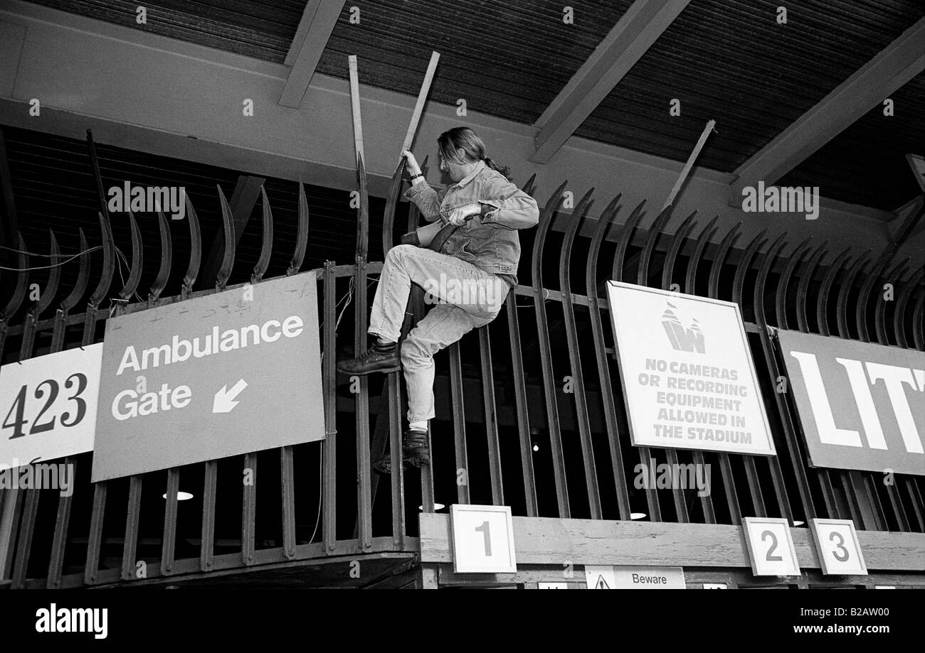 Sostenitore di calcio che si arrampica sul recinto a Wembley Stadium per guardare il 1996 finale di FA Cup tra Liverpool e Manchester Utd. Foto Stock