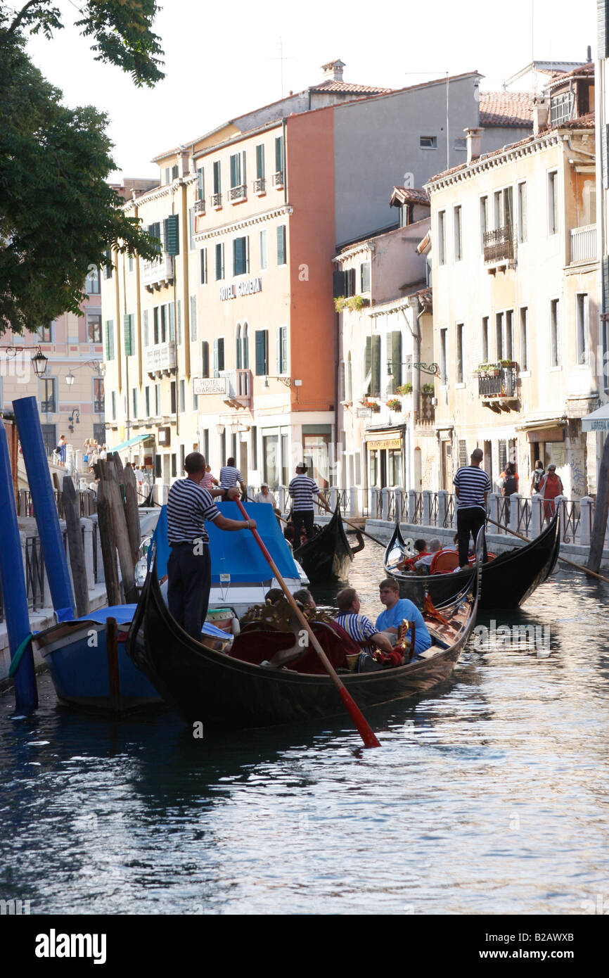 Turisti che si godono una serata giro in gondola lungo i canali di Venezia. Foto Stock