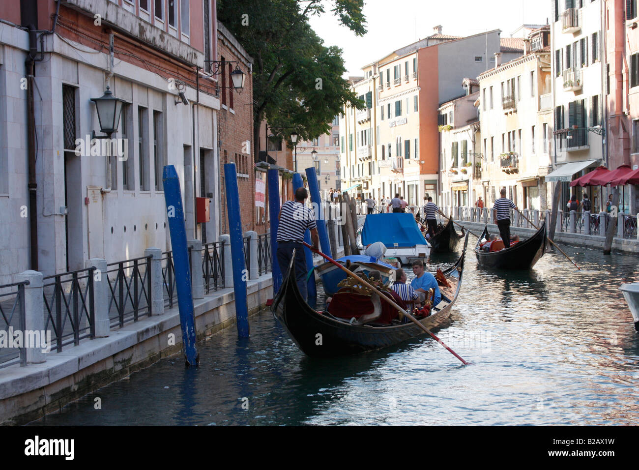 Turisti che si godono una serata giro in gondola lungo i canali di Venezia. Foto Stock