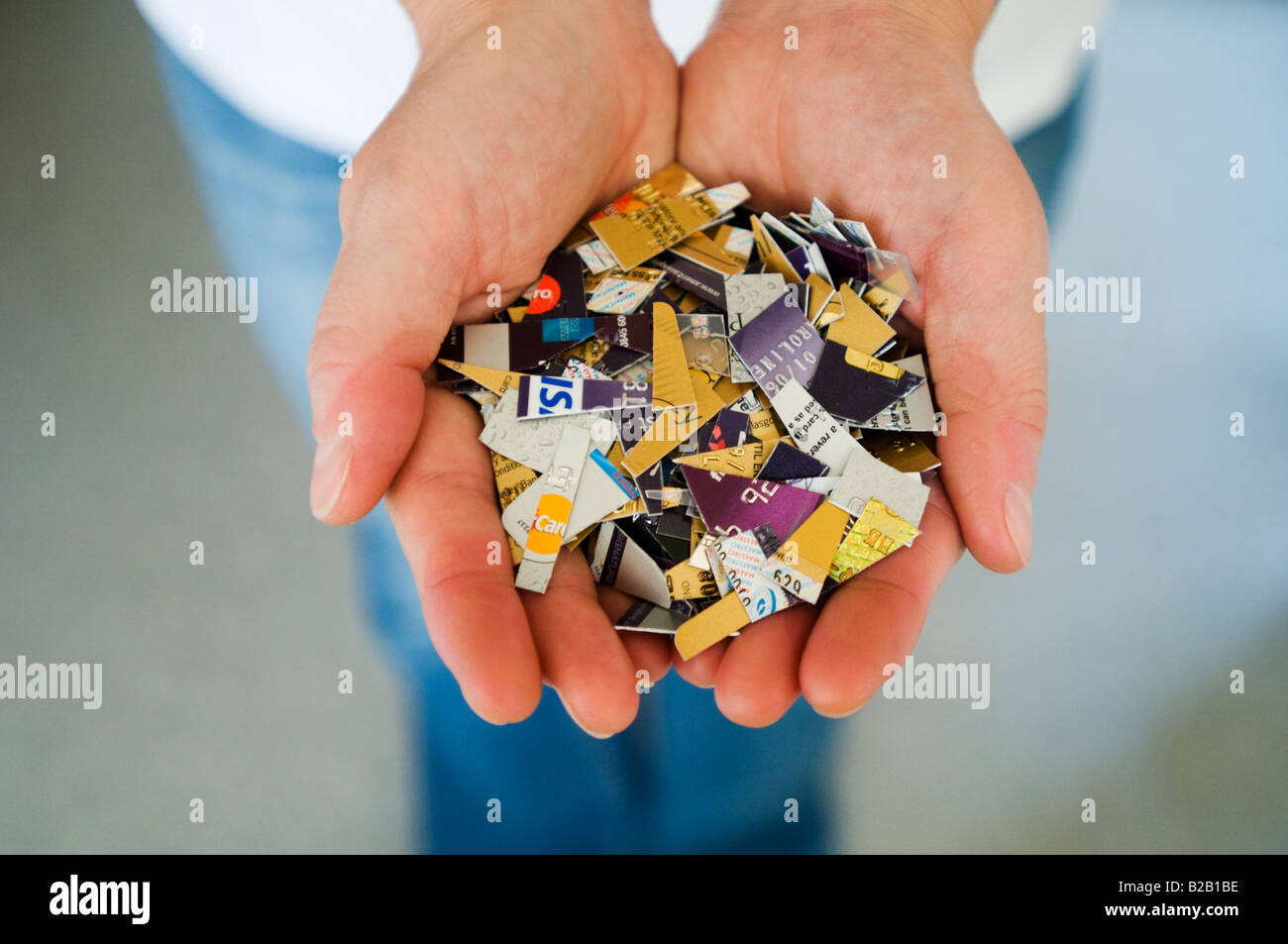 Una donna può contenere un numero di carte di credito e di debito che sono state tagliate in le palme delle mani. Foto Stock