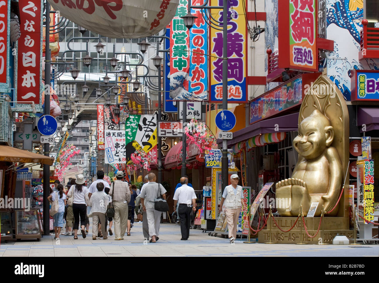 Grande golden Billiken statua a guardare oltre la Shin Sakae quartiere dello shopping di Tennoji Osaka Foto Stock