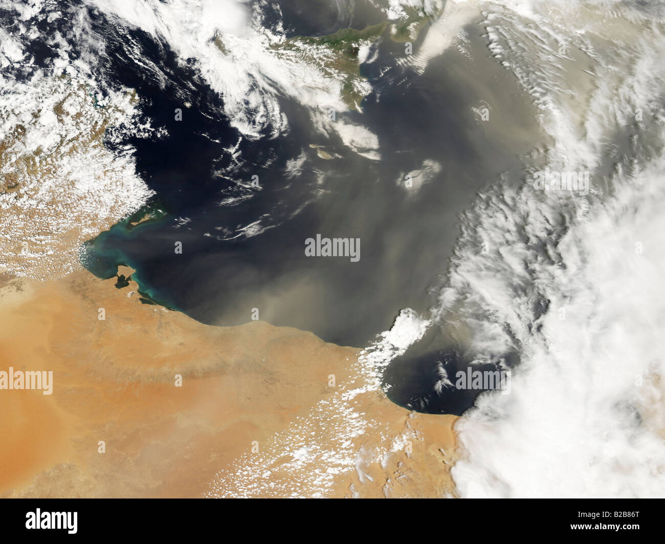 Pennacchi di polvere soffiando fuori della costa nord africana e al di sopra del Mare Mediterraneo. Foto Stock
