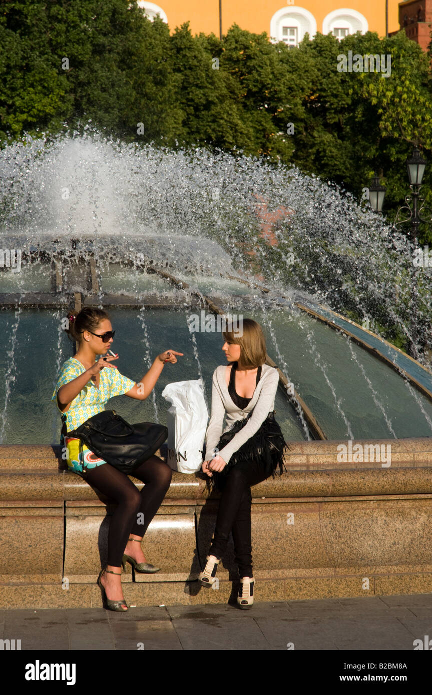 Giovani donne seduto accanto a una fontana in Manege Square, Mosca, Russia Foto Stock