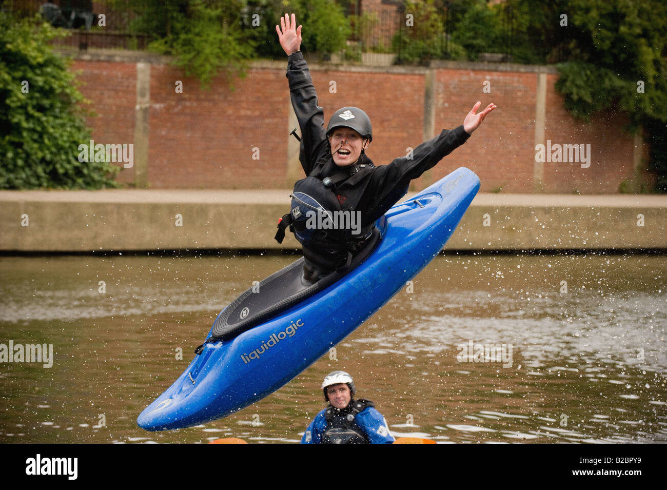 Una donna caucasica sorridente, che sorride nell'aria, si ferma in un playboat blu che sta per atterrare nel Foss Basin al festival del fiume York 2008. Foto Stock