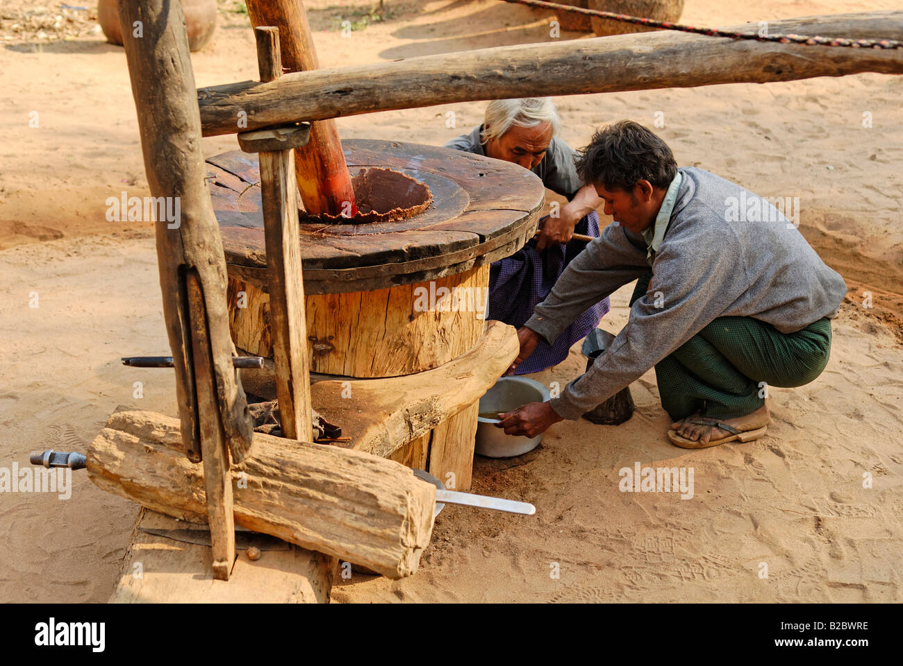 Due uomini in un mulino di arachide o dado di massa olio, birmania, myanmar, Asia Foto Stock