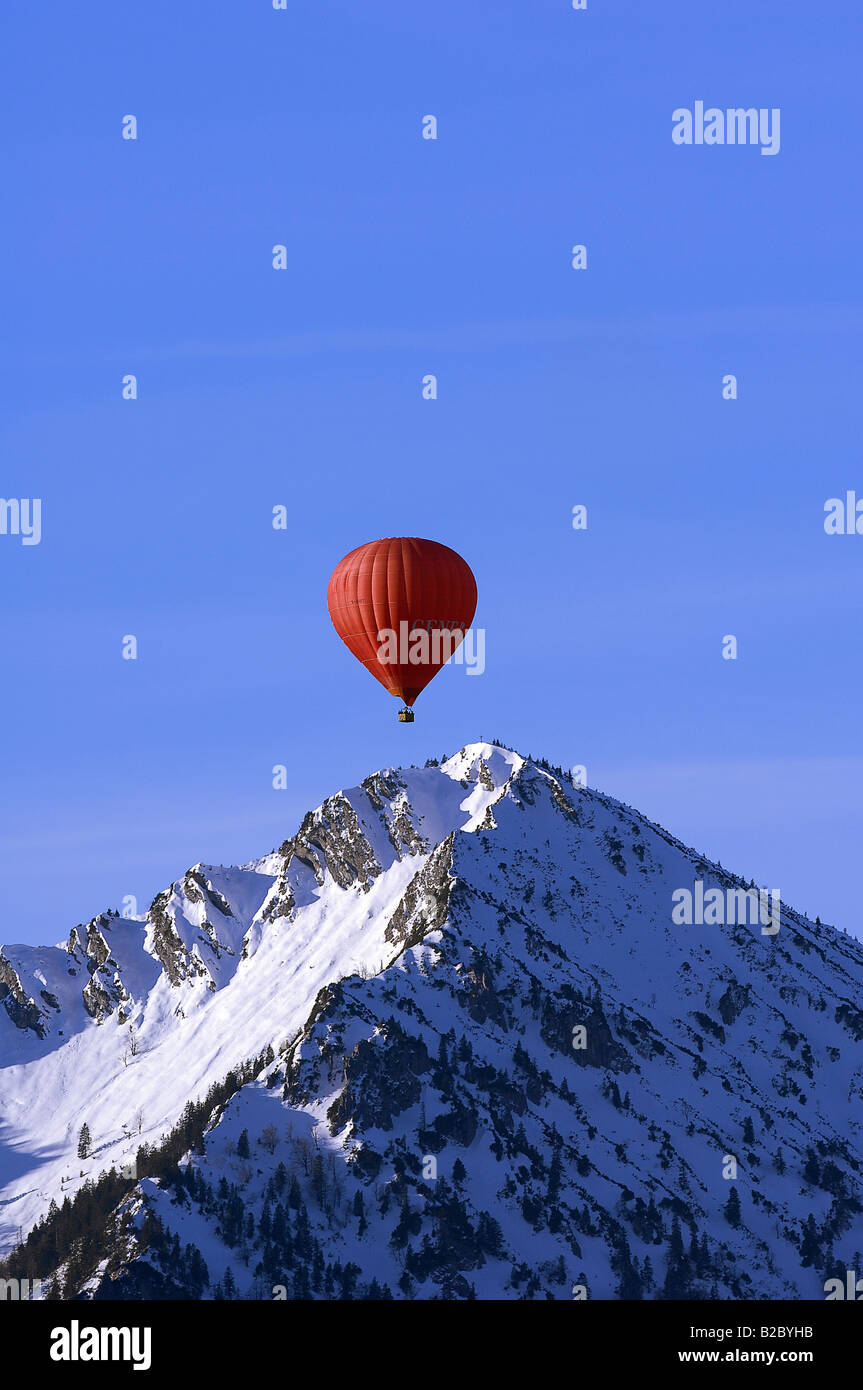 Red mongolfiera galleggianti al di sopra del picco di Mt. Ochsenkamp, Montgolfiade, Tegernsee, Bad Wiessee, Baviera, Germania, Europa Foto Stock