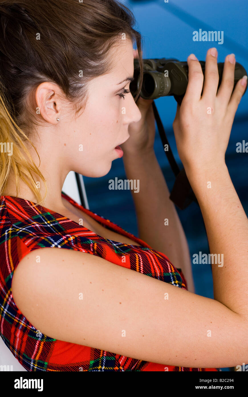 Giovane donna attraente con un binocolo Foto Stock