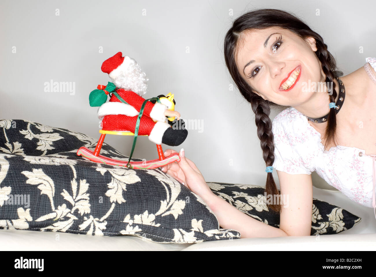 Giovane donna con due trecce e Santa Claus doll Foto Stock