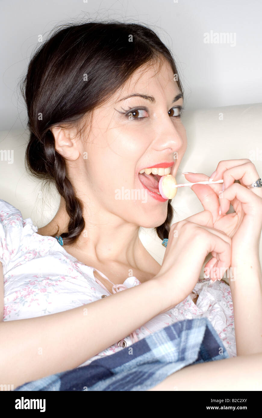 Giovane donna con due trecce e per lecca-lecca Foto Stock