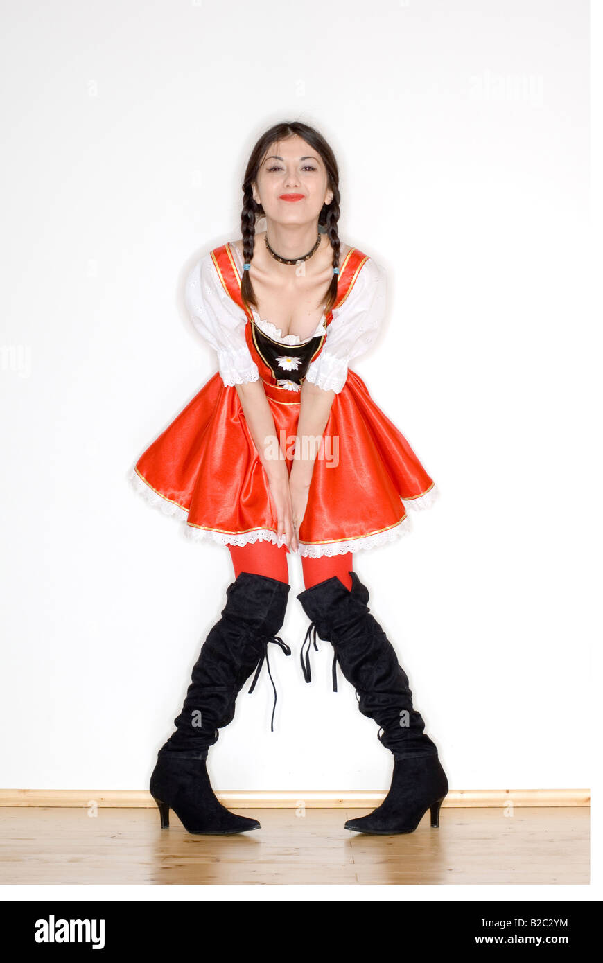 Giovane donna con due trecce che indossa un vestito con grembiule e jackboots Foto Stock