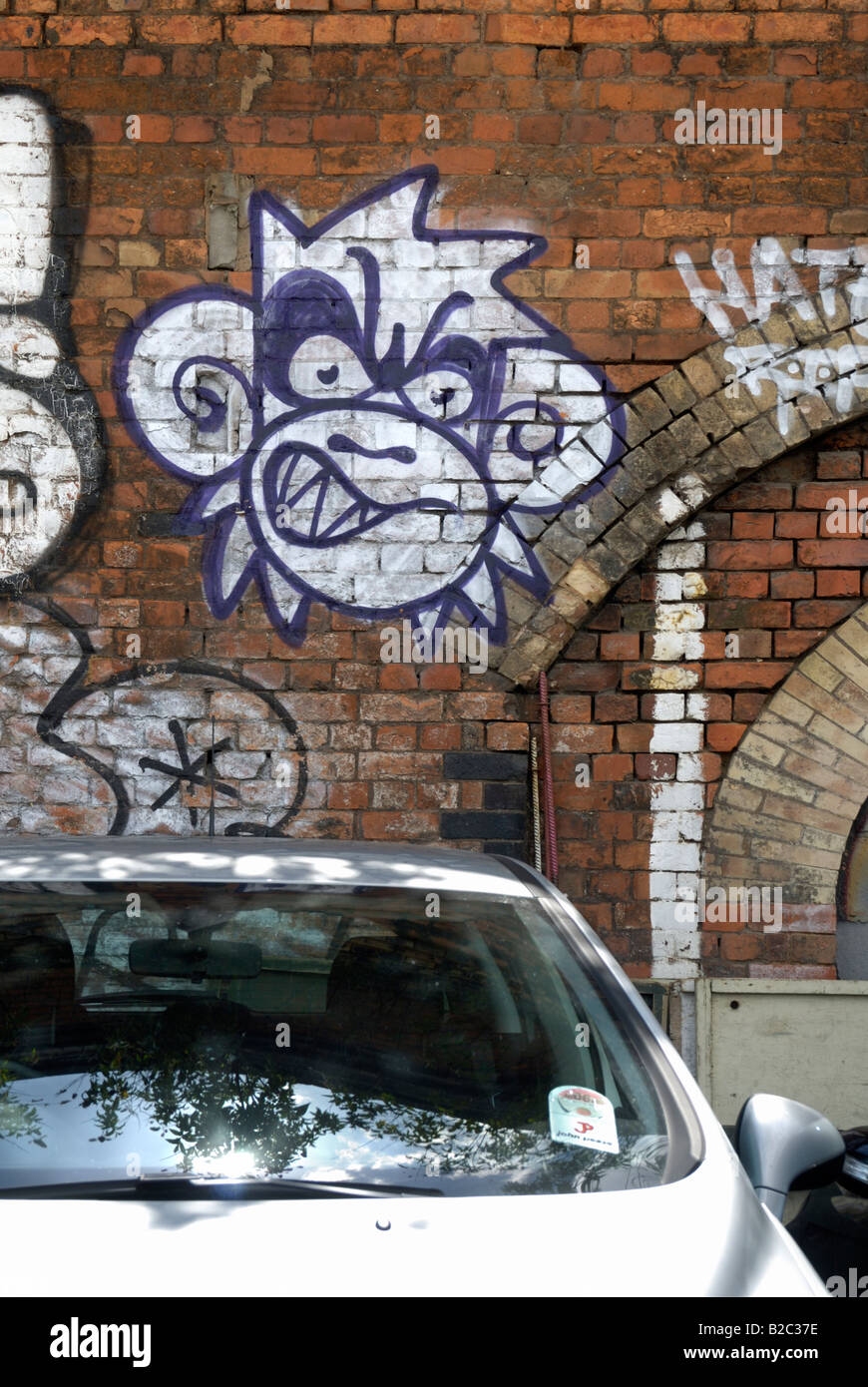 Macchina parcheggiata di fronte un murale di una scimmia sulla parete in mattoni, Londra Foto Stock Macchina parcheggiata di fronte un murale di una scimmia sulla parete in mattoni, Londra Foto Stock