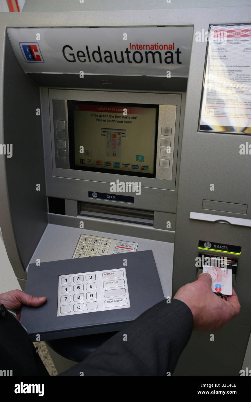 Dipendente della Banca dimostrando dispositivi tecnici utilizzati dai criminali per spiare i numeri e codici pin di carte bancarie in una macchina ATM Foto Stock