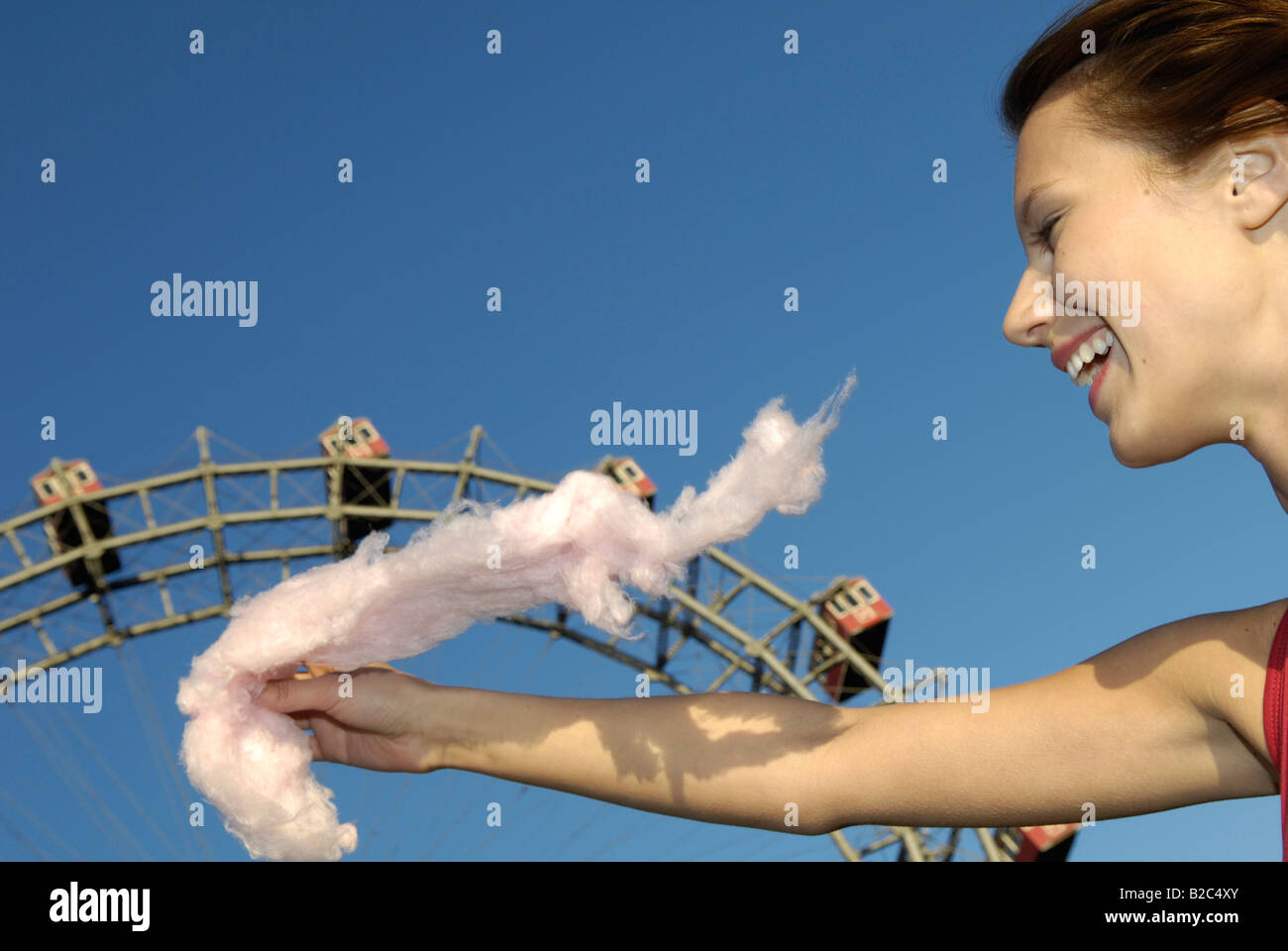 Il parco di divertimenti Prater di Vienna, giovane donna con candy floss, gigante ruota di traghetto Foto Stock