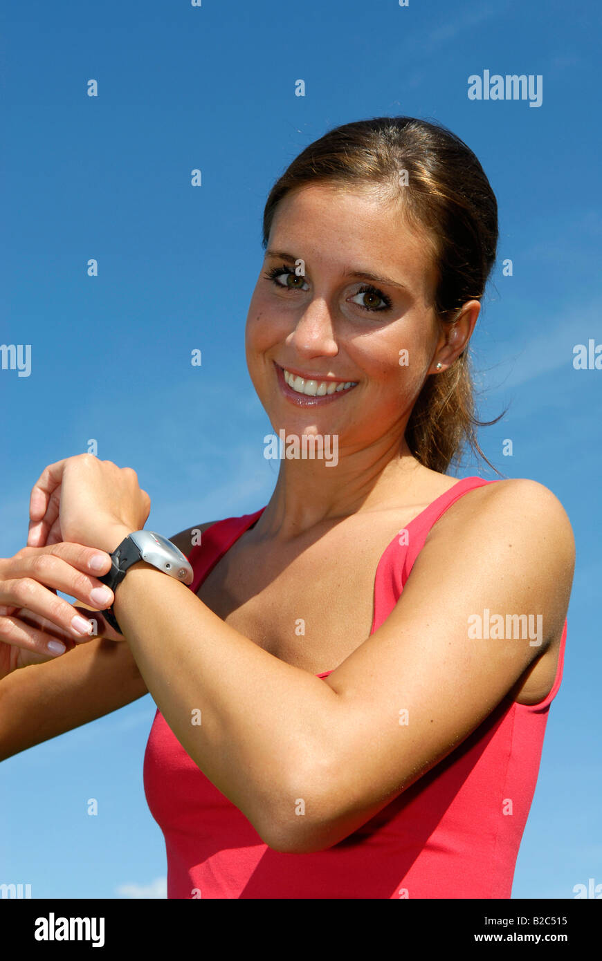 Giovane donna in esecuzione con impulsi di orologio Foto Stock