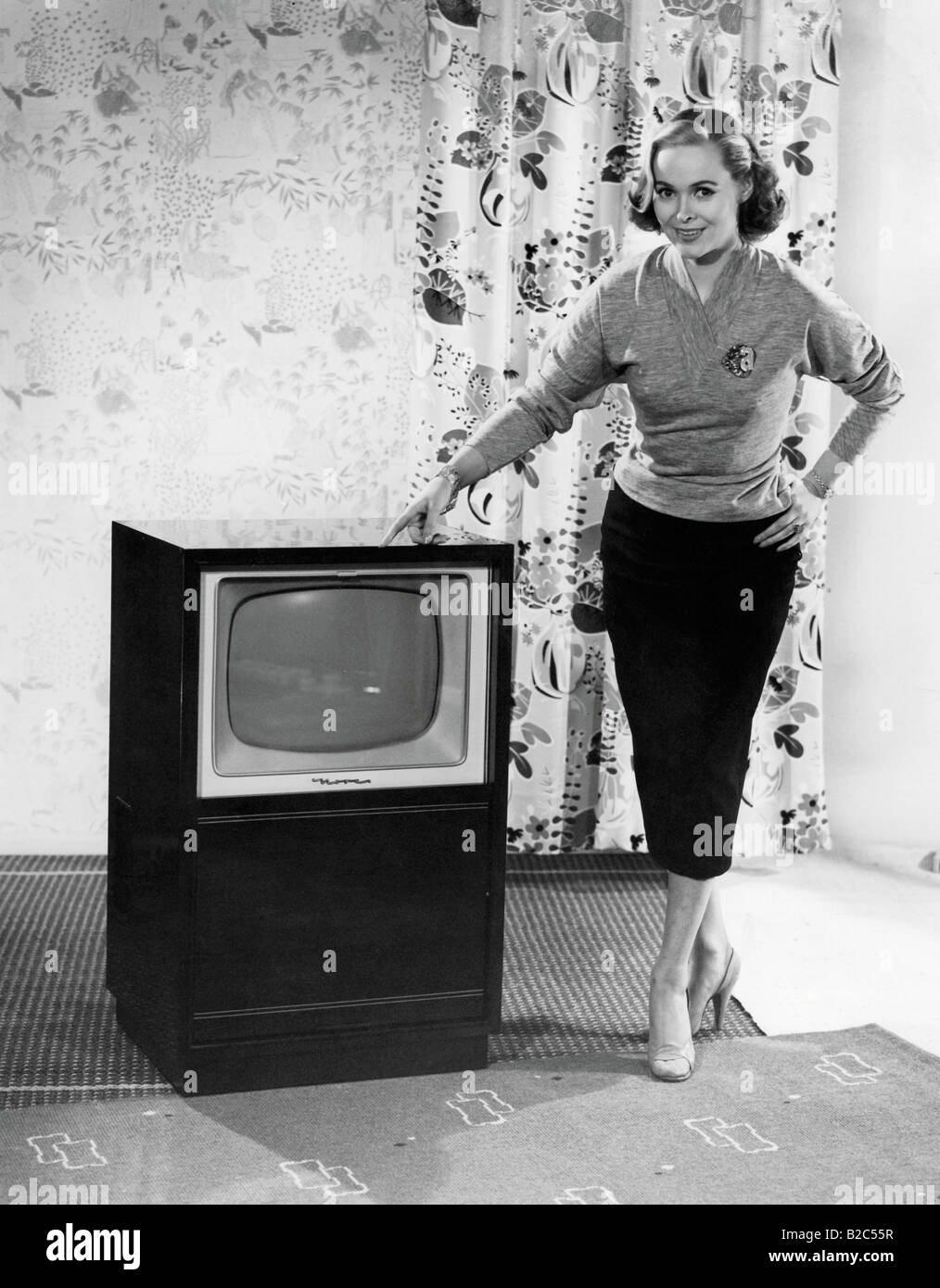 Donna in posa accanto a un televisore, la storica foto da circa 1955 Foto Stock